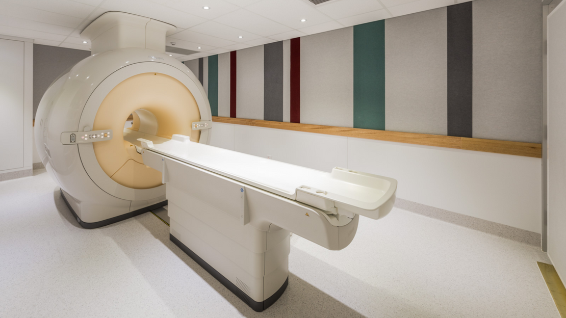 Magnetic resonance imaging (MRI) machine in a clinical setting with striped walls. 
