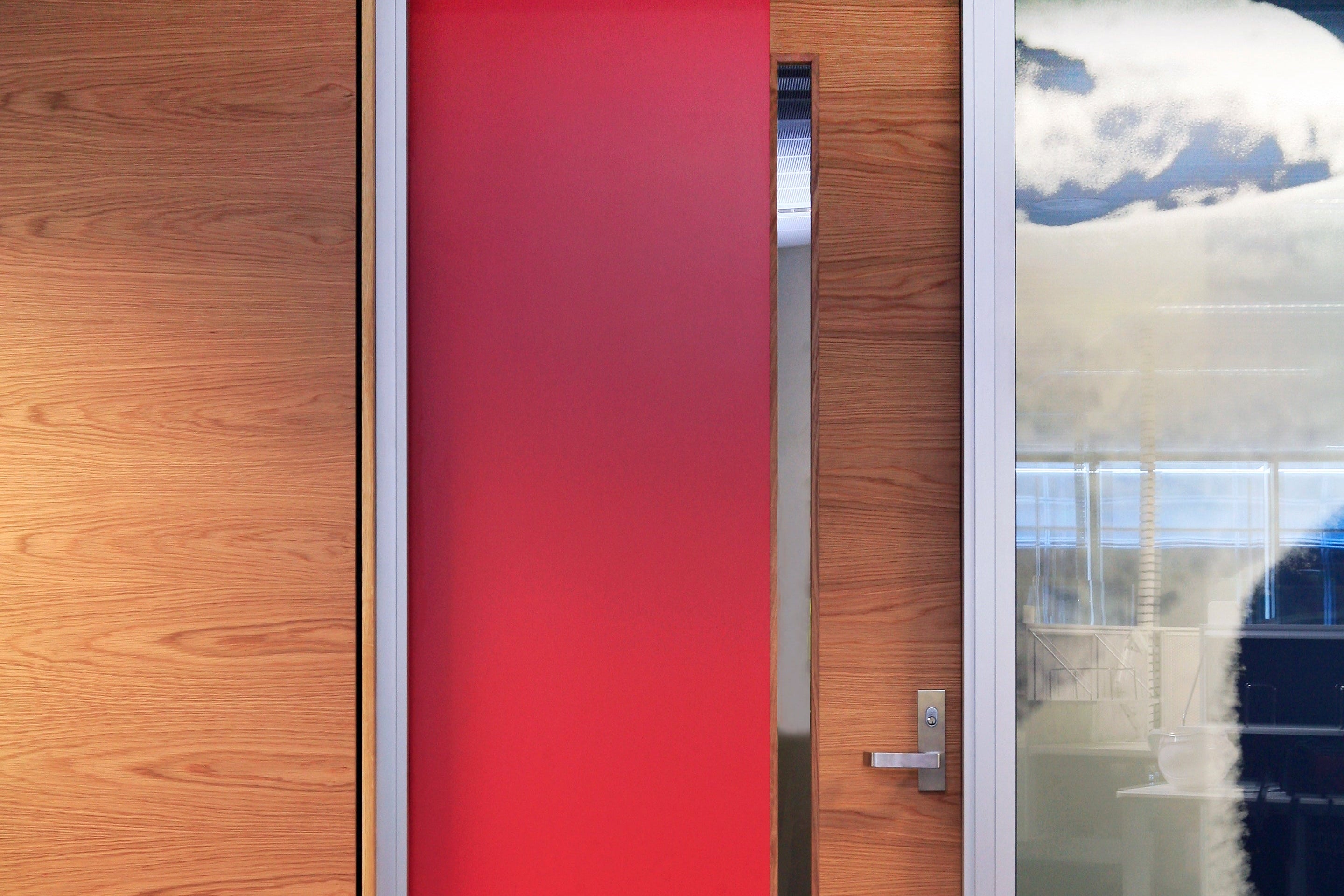 Studform wooden door with a red glass panel and a glass panel on the right in a commercial environment. 