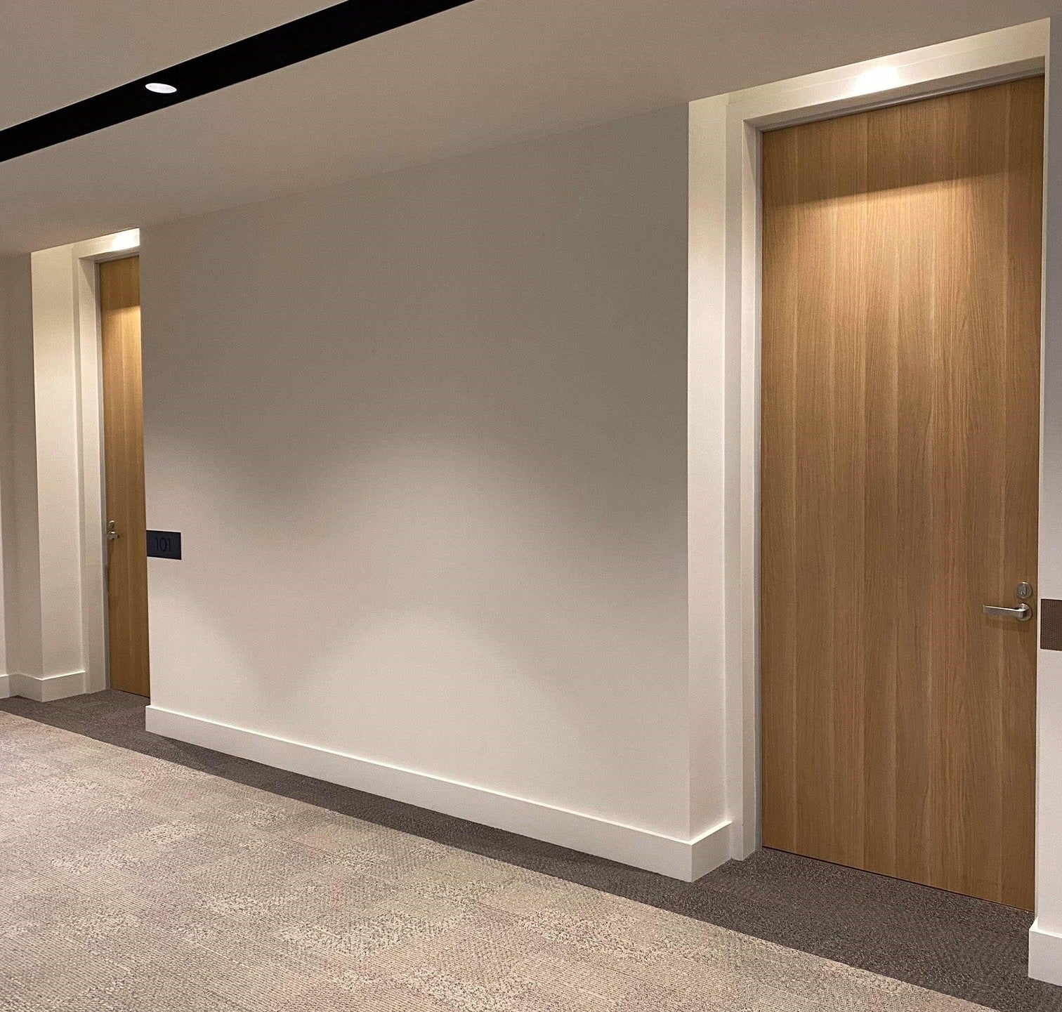 Modern apartment building with Studform timber doors and neutral walls.