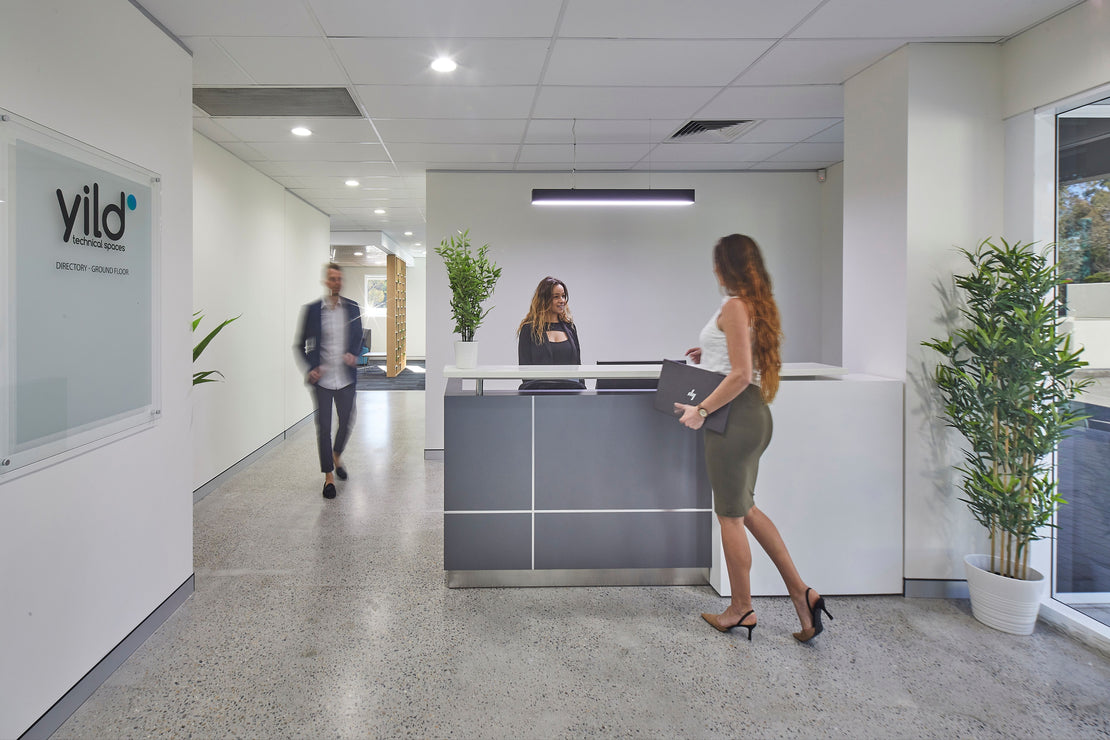 Person walking through a modern office with 'yild' branding on a glass wall.
